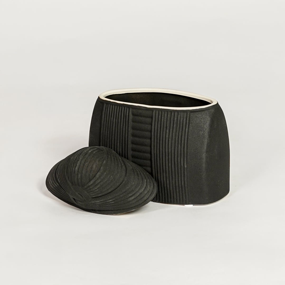 Contemporary black ceramic storage jar with fitted lid perfect for entryway table living room or dining decor display.