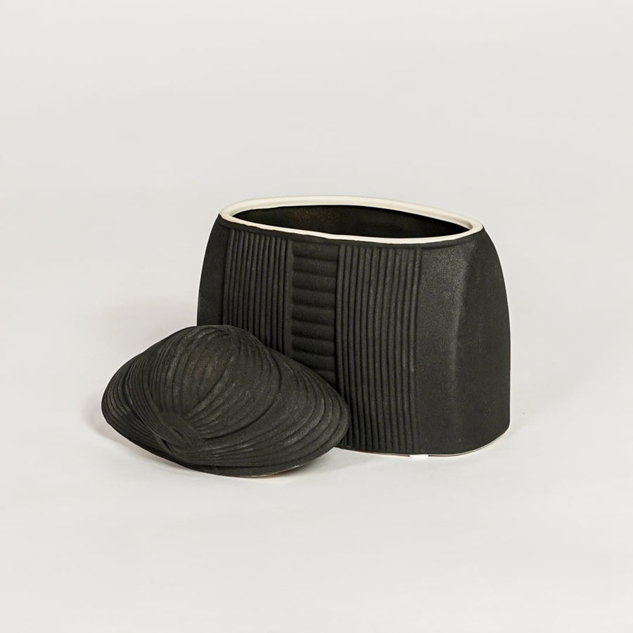 Contemporary black ceramic storage jar with fitted lid perfect for entryway table living room or dining decor display.