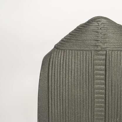 Closeup of matte dark green ceramic jar with fine vertical ribbed detailing ideal for shelf or side table decor styling.