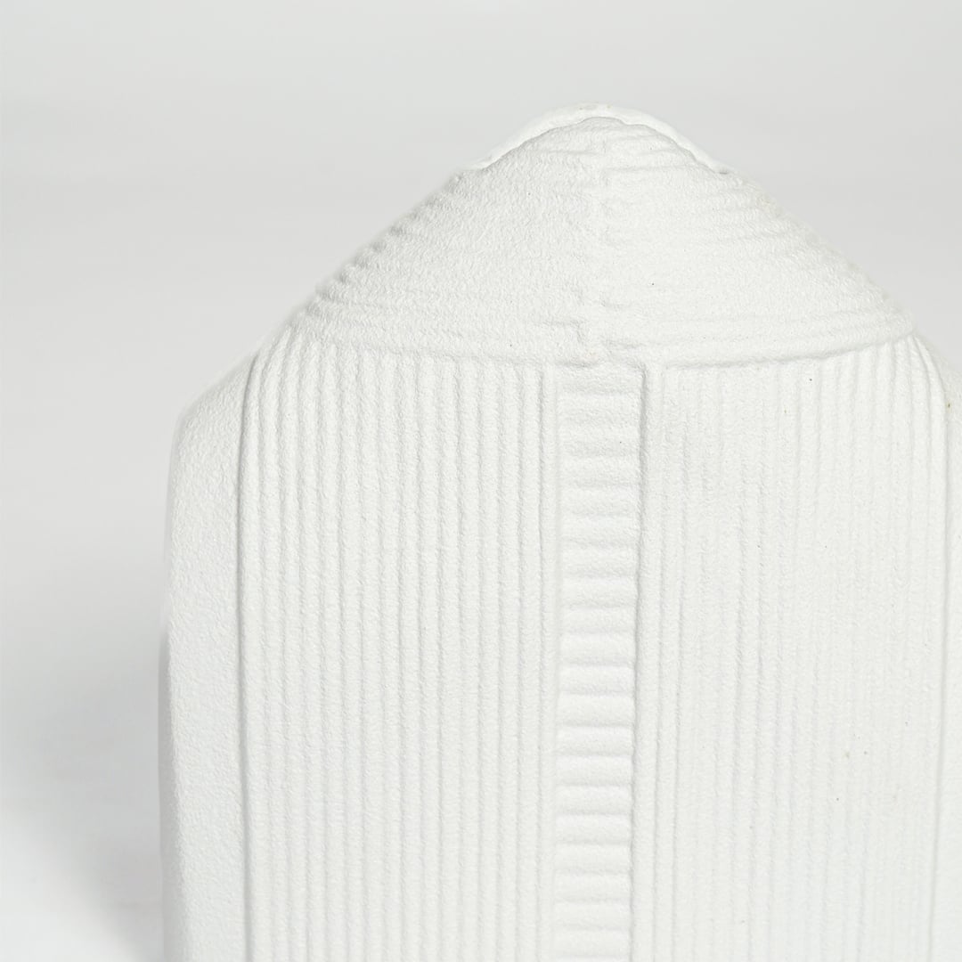 Detailed closeup of white ceramic dome vase showcasing vertical ribbed texture and smooth matte surface.