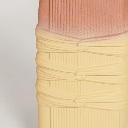 Closeup of matte yellow ceramic vase with terracotta top and handcrafted texture ideal for elegant home decor styling.