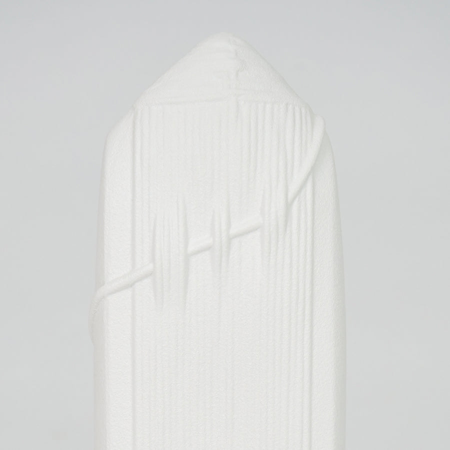 Closeup image of white ceramic abstract sculpture for modern shelf placement with artistic textured matte finish.