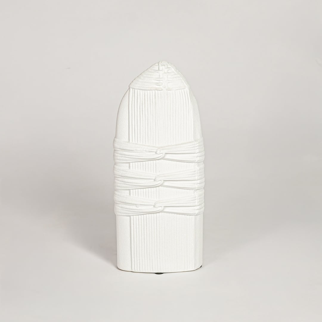 White ceramic sculpted decorative vase with vertical ribbed detailing isolated on white background for elegant home decor use.