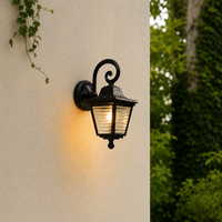 Classic black iron scroll arm ribbed glass wall lantern on beige exterior stucco facade for residential porch lighting.