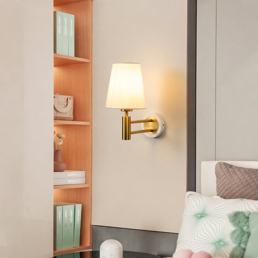 Gold metal wall light lifestyle image with fabric shade for cozy modern bedroom wall lighting decor.