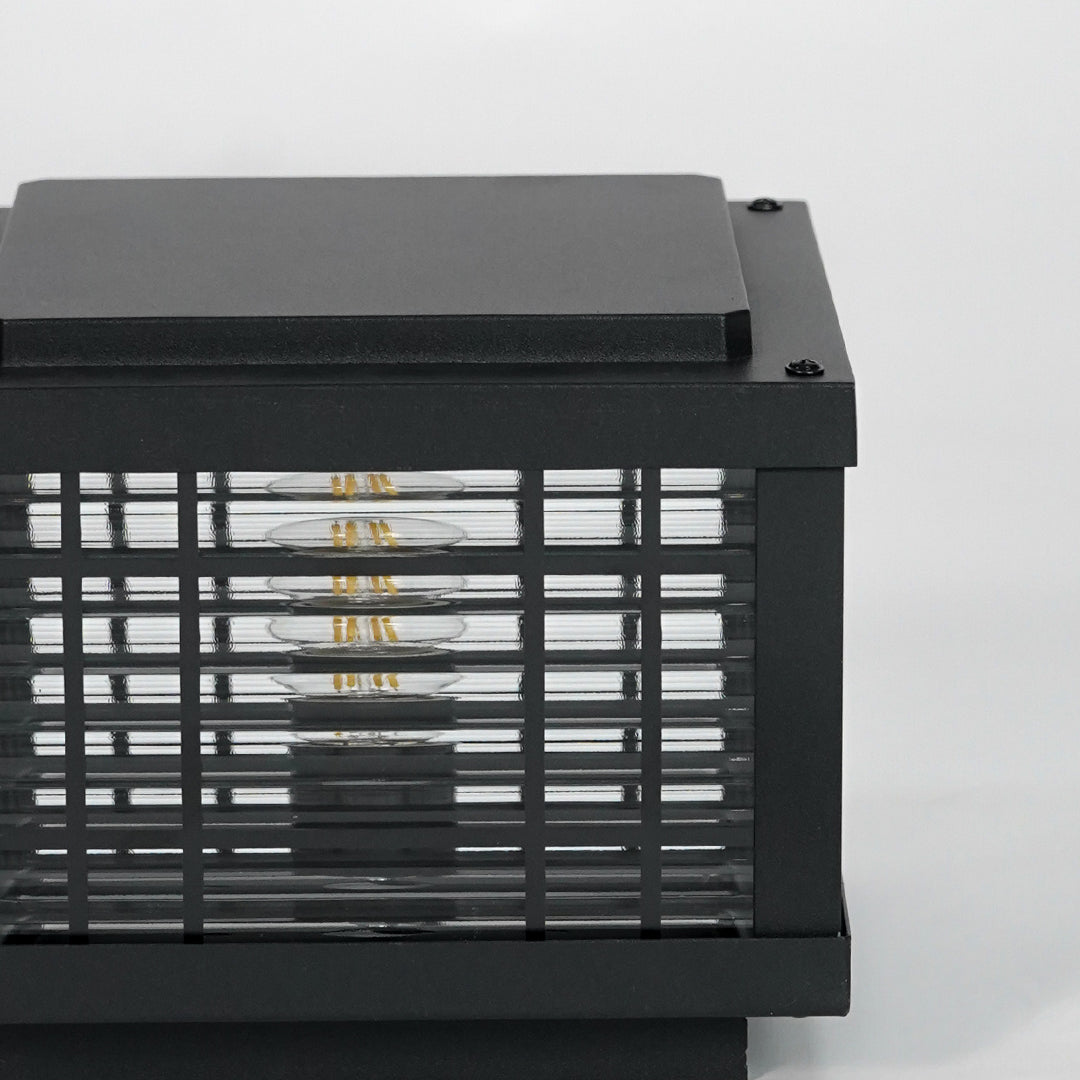 Closeup of black metal outdoor gate light with mesh frame for modern exterior decor styling use.