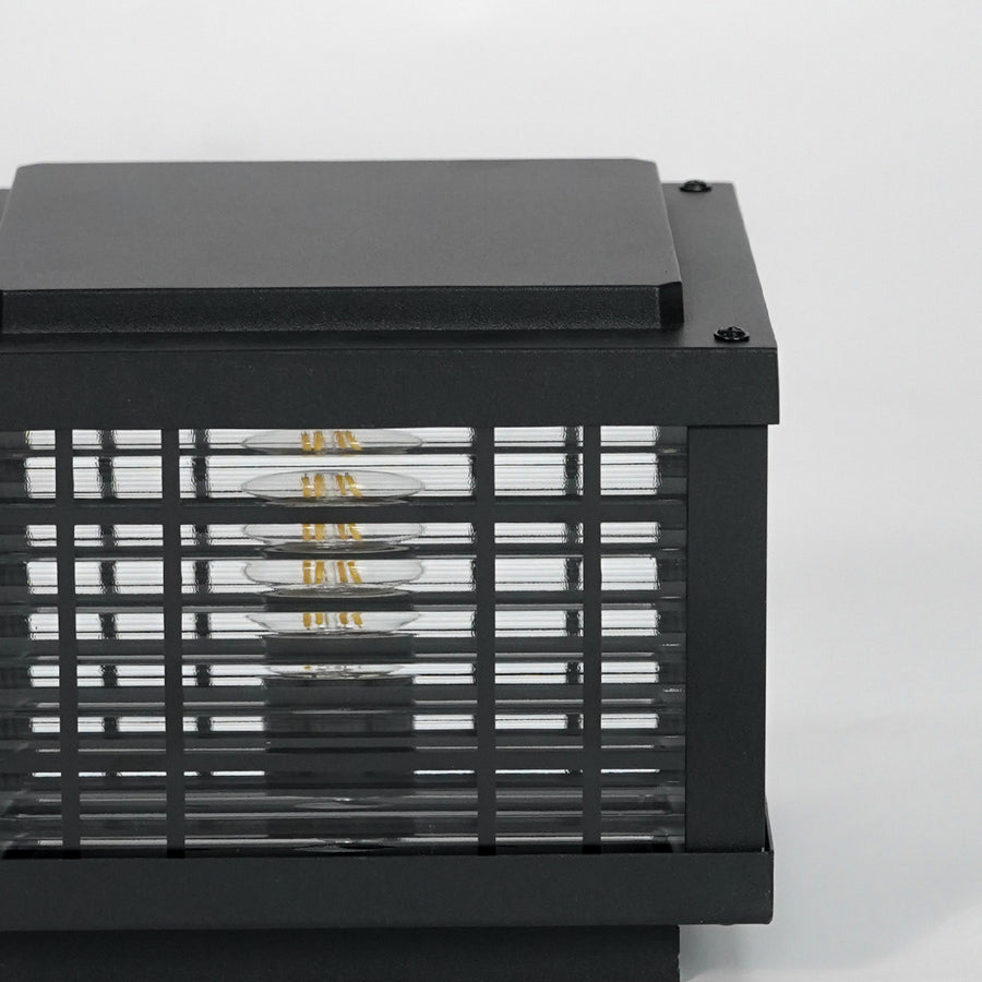 Closeup of black metal outdoor gate light with mesh frame for modern exterior decor styling use.