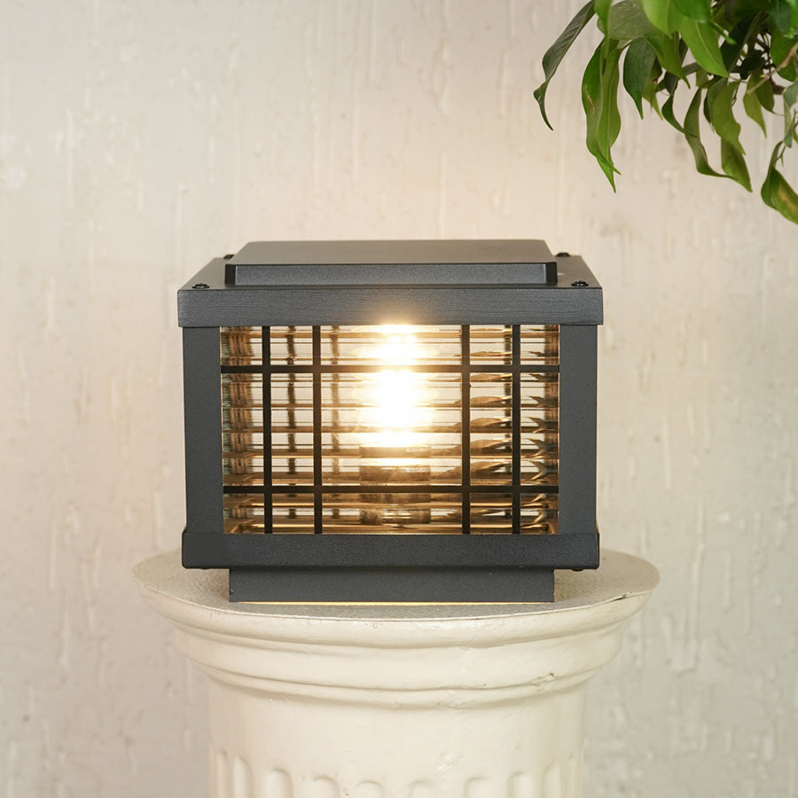 Black outdoor gate light with warm glowing bulb for elegant modern exterior decor styling use.