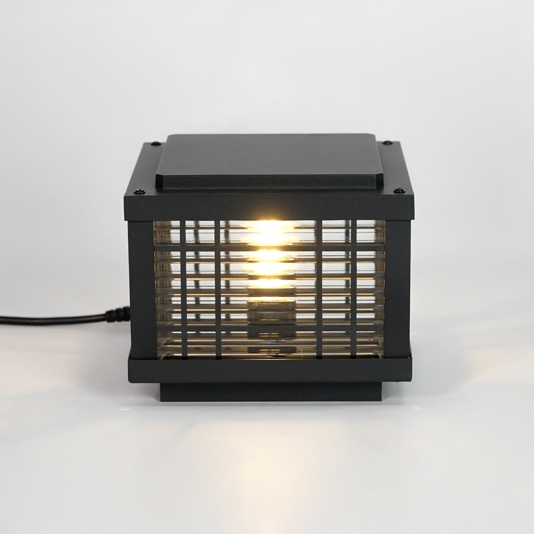 Black metal outdoor gate light with glowing bulb for stylish exterior decor styling use.