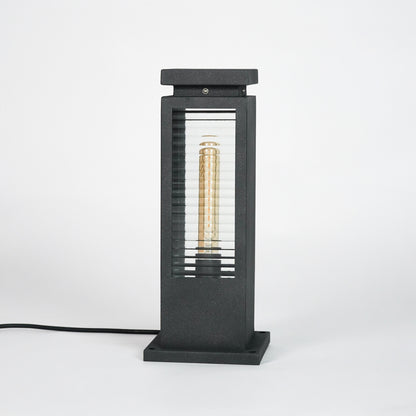 Black metal outdoor pathway light with glass enclosure for modern garden and exterior lighting decor placement.