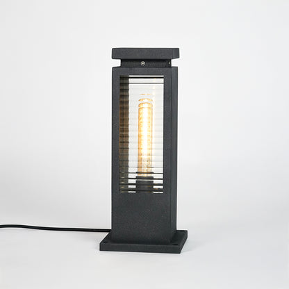Black metal outdoor bollard light with clear glass panels for modern exterior lighting decor placement styling.