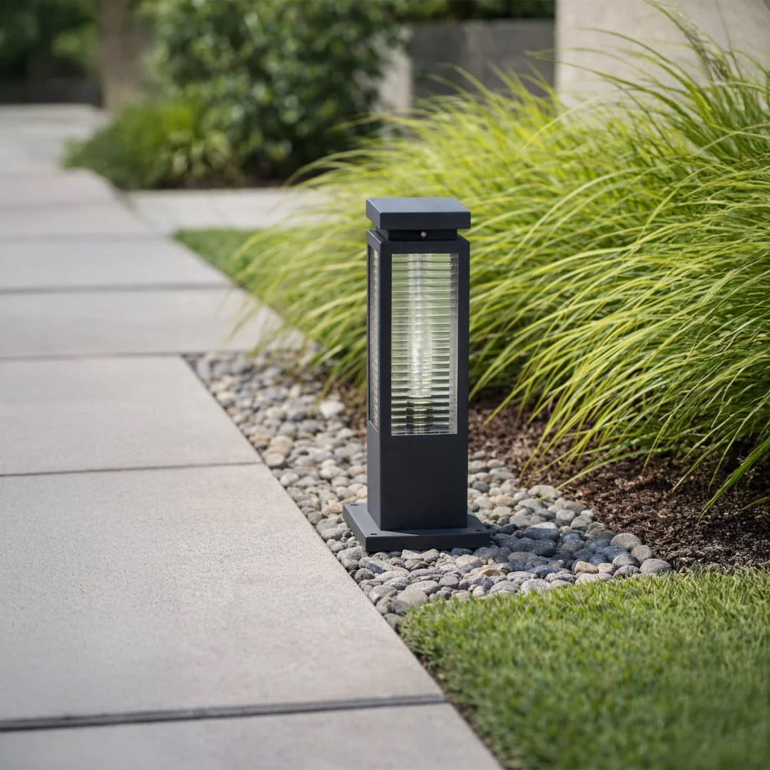 Black metal outdoor bollard light with warm glow for elegant modern garden pathway lighting decor styling.