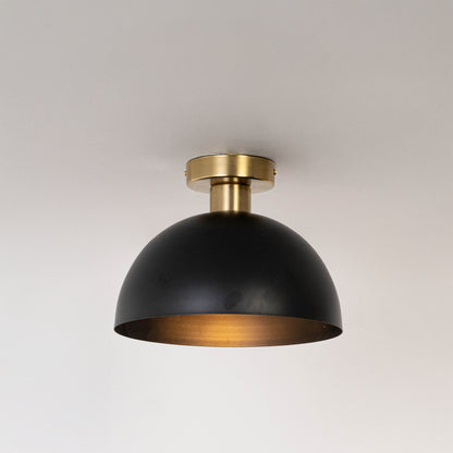 Modern black metal dome ceiling light with warm glow for contemporary bedroom and minimalist decor styling spaces.
