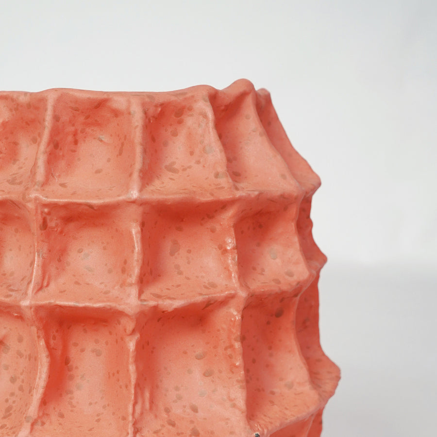 Closeup image of coral ceramic textured decor vase for modern tabletop styling with artistic geometric finish.