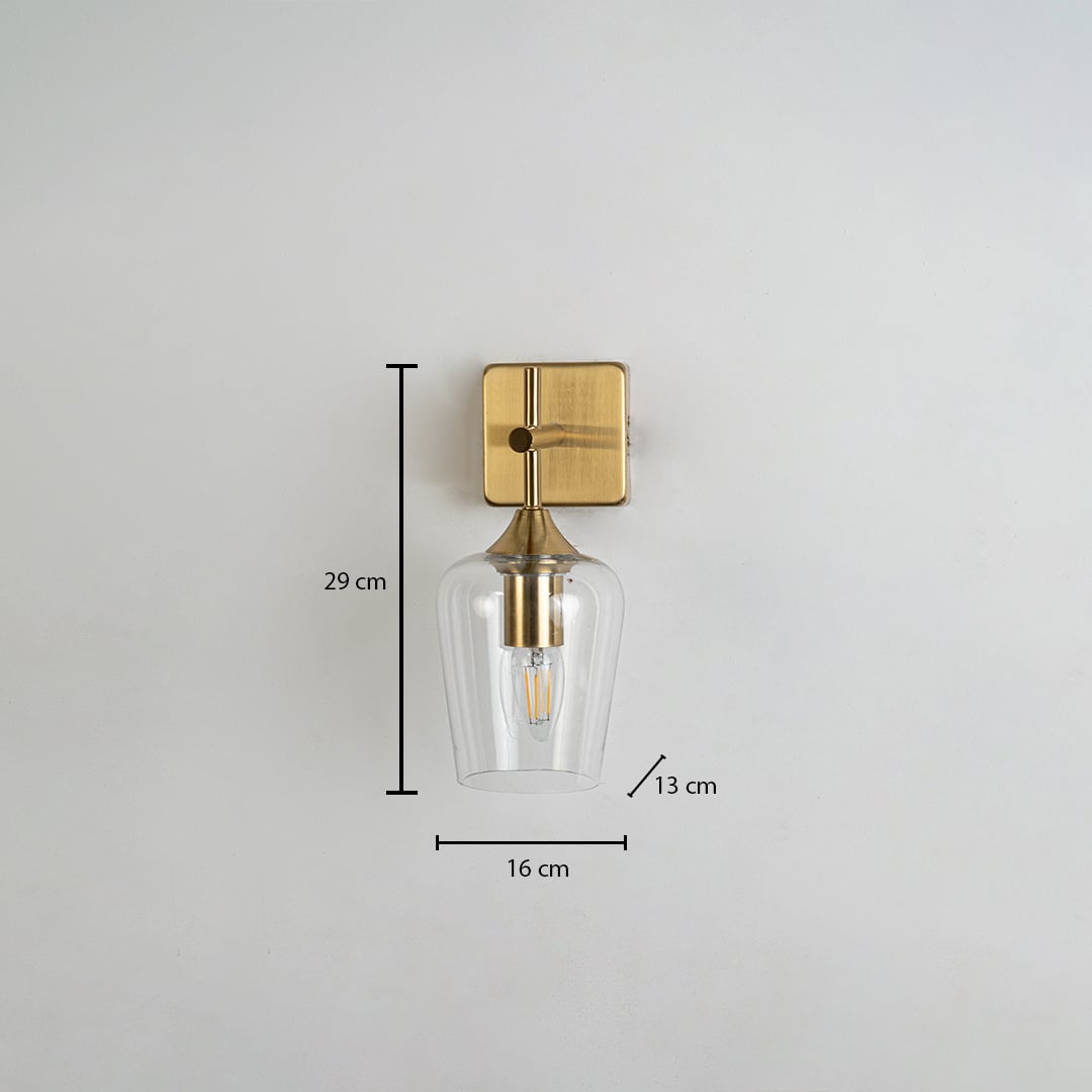Clear glass wall light with gold metal base shown with measurements including 29 cm height 16 cm width and 13 cm depth clearly marked on a white background.