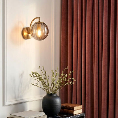 Lifestyle image of grey modern globe brass wall light for elegant bedroom decor styling and contemporary home lighting.