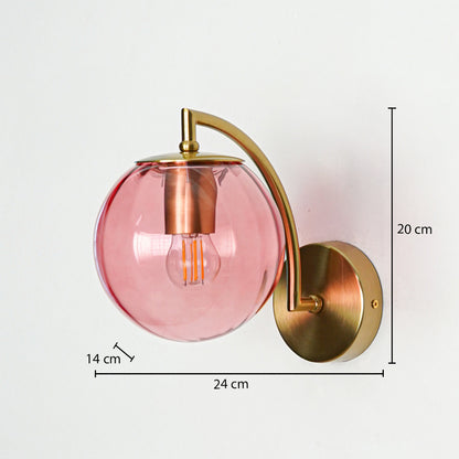 Stylish pink glass wall light with gold metal mount displayed against clean white background suitable for modern bedroom or living space lighting.