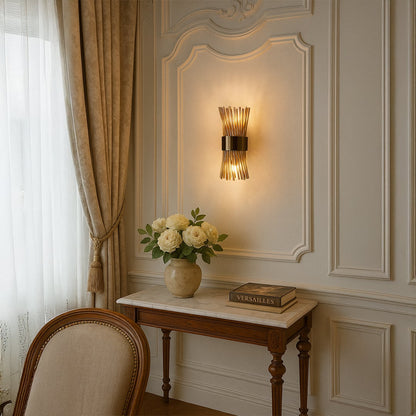 A gold metal and glass rod wall light glowing warmly in a classic interior setting adding soft ambient lighting to enhance elegant living room decor.