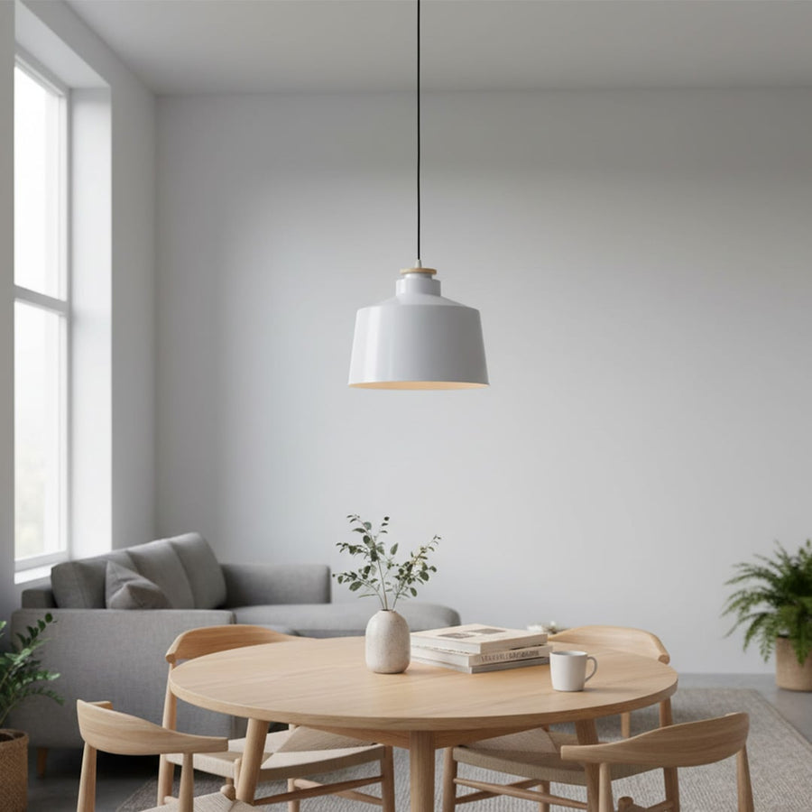Pendant light with white metal shade hanging above dining table adding clean modern lighting and calm elegance to interior space.
