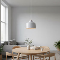 White metal pendant light above dining table adding Scandinavian elegance and warm ambient lighting to modern interiors.