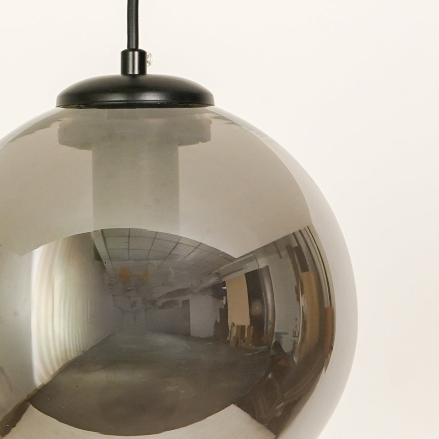 Smoked glass globe pendant light with black fittings adding elegant charm to modern ceiling decor.