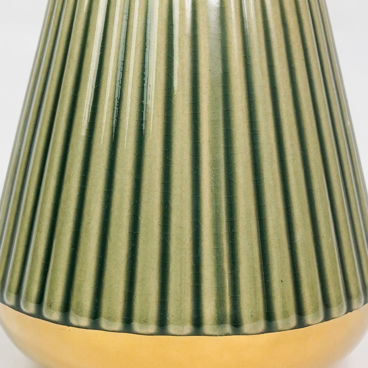 Closeup image of minimalist green gold ceramic vase for elegant tabletop decor styling highlighting modern smooth finish.
