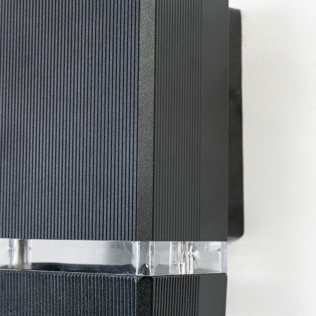 Detailed view of compact rectangular wall light featuring ribbed matte finish and frosted glass diffuser strip.