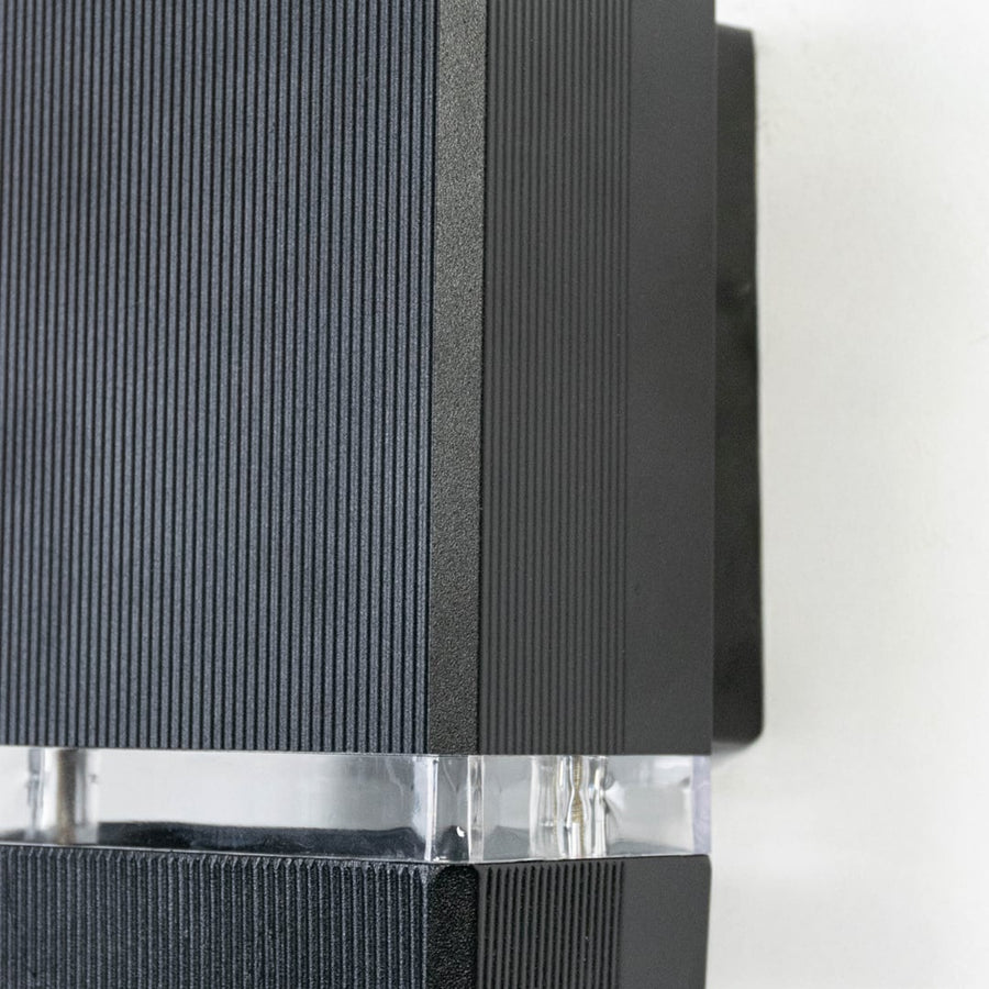 Detailed view of compact rectangular wall light featuring ribbed matte finish and frosted glass diffuser strip.