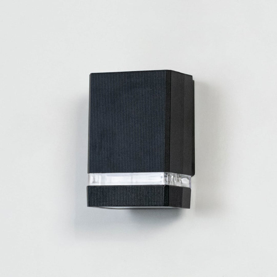 Compact black wall light against white background displaying clean lines and translucent middle panel design.