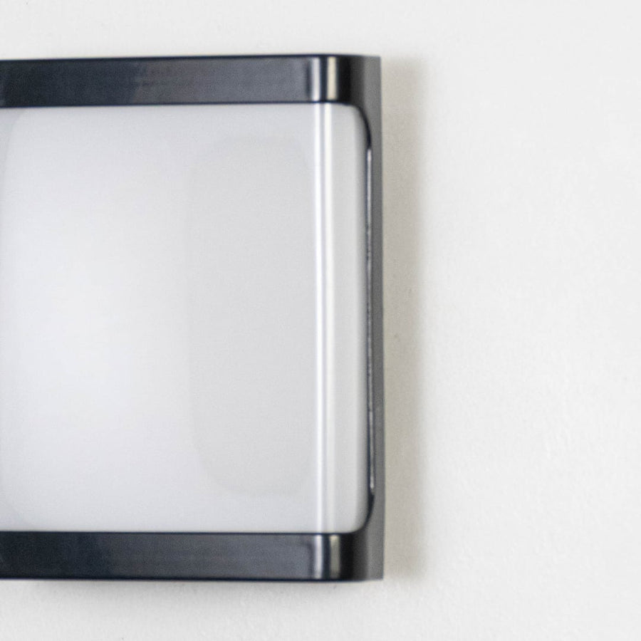 Closeup of outdoor wall light showing frosted rectangular diffuser smooth metal frame and clean contemporary design finish.