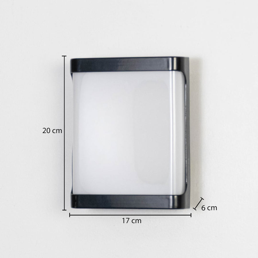 Modern outdoor wall light in black metal with frosted glass mounted on wall showing 20 cm height 17 cm width and 6 cm depth.
