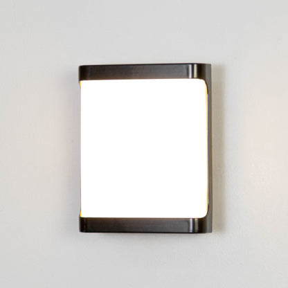 Black metal wall light on white background with frosted glass shade for minimalist modern decor.
