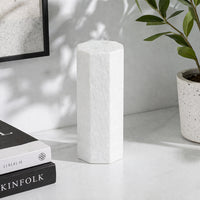 White textured ceramic vase placed on shelf beside books for elegant modern home decor styling.