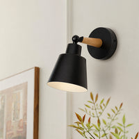 Modern wall light installed above a wooden sideboard creating a warm ambient glow that enhances a calm living space with soft decor textures and minimalist styling.
