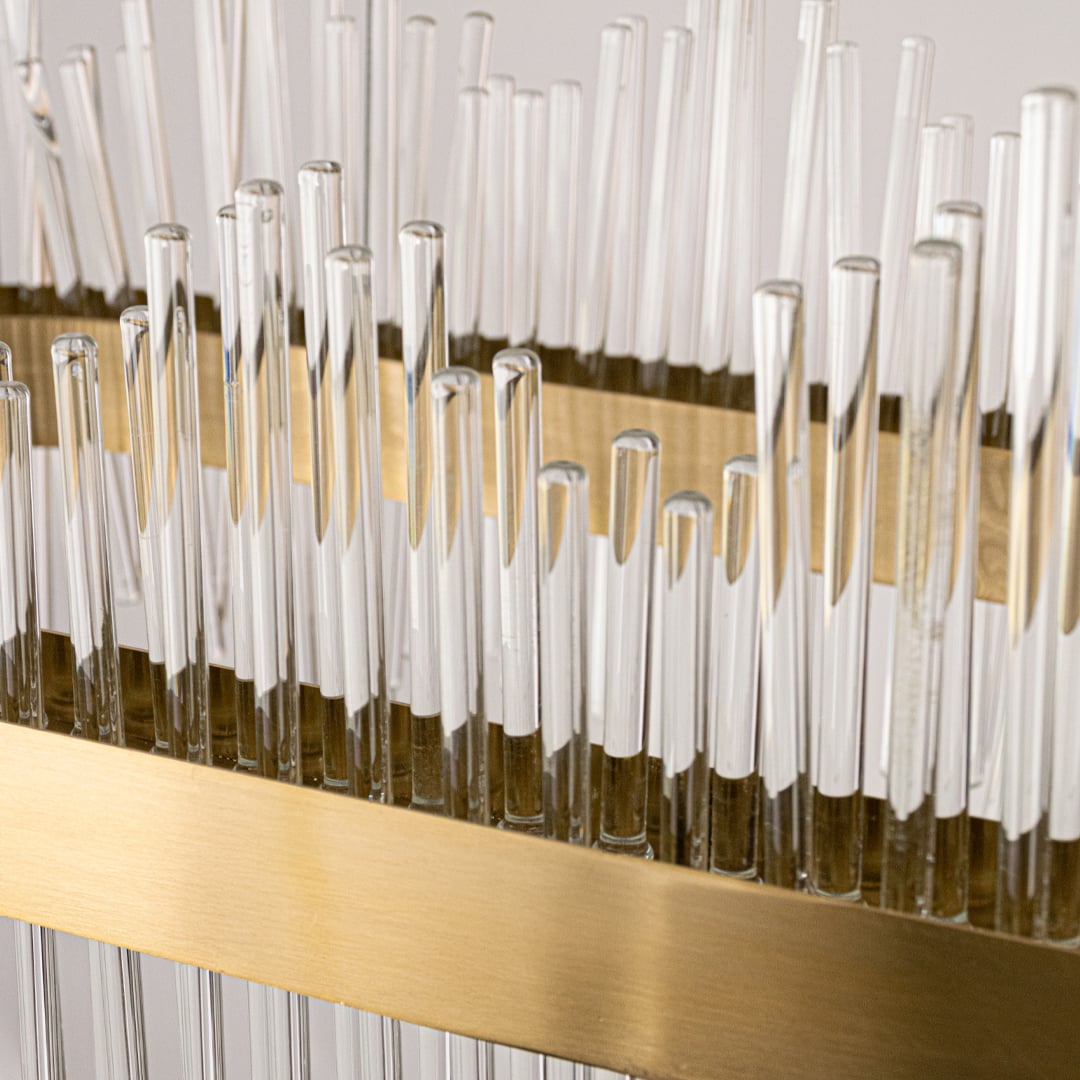 Closeup of gold metal chandelier highlighting the detailed glass rods and polished metal band designed for elegant premium interior lighting.