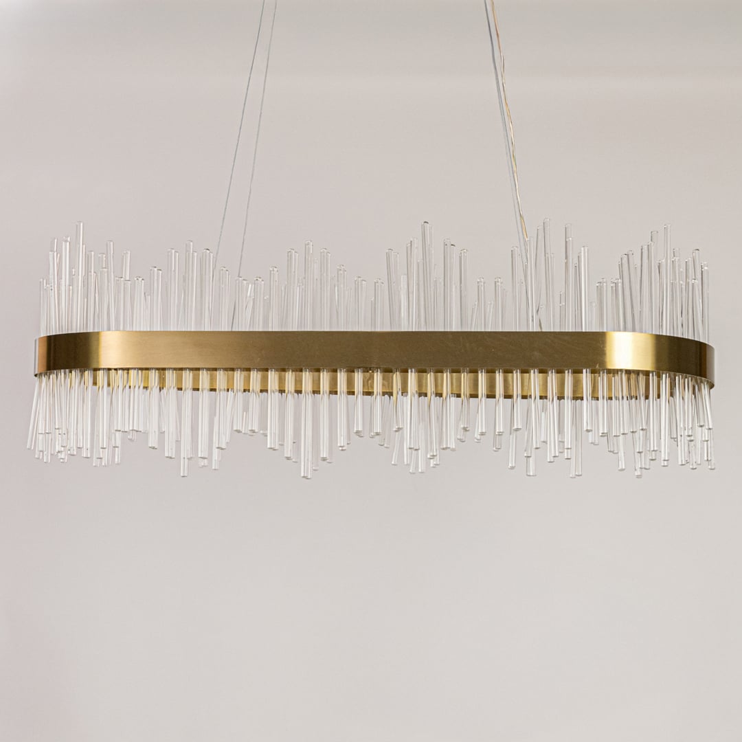 Gold metal chandelier with vertical glass rods displayed with lights off on a white background showing its sleek contemporary structure.