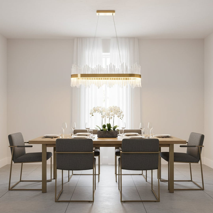 Gold metal chandelier with clear glass rods glowing warmly above a modern dining table creating an elegant bright and luxurious interior atmosphere.