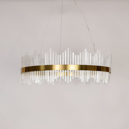 Linear chandelier with clear glass rods and gold metal frame suspended on off white background for luxury interior lighting.