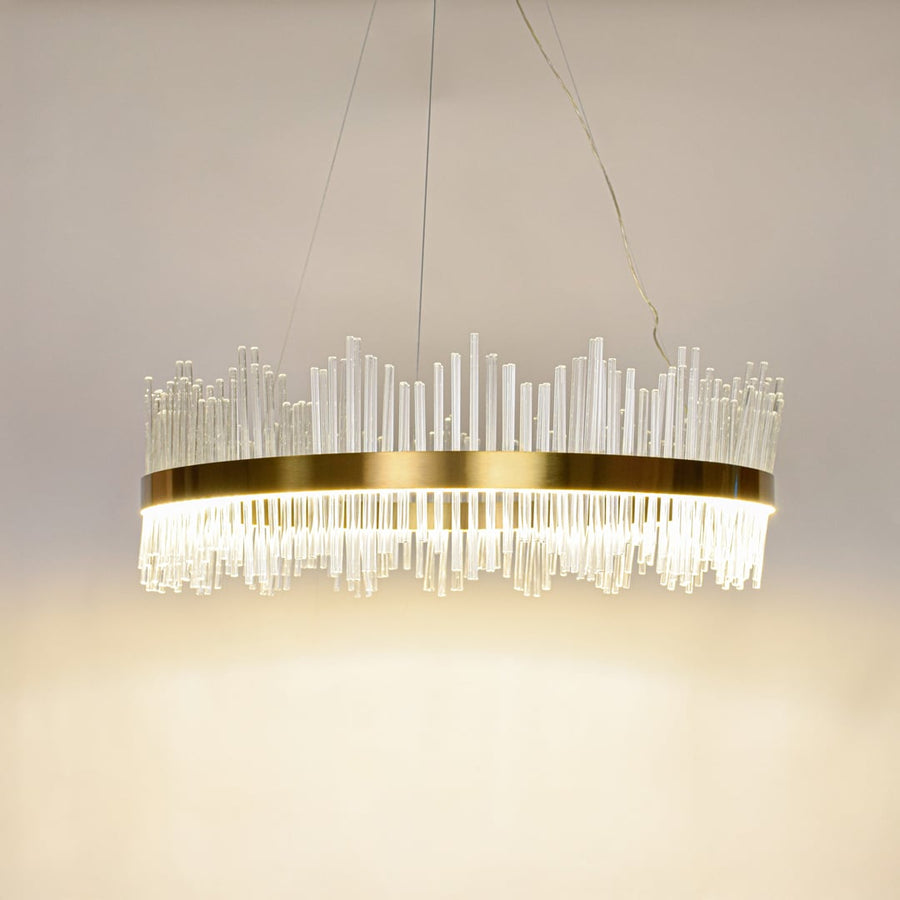 Designer gold metal chandelier glowing with clear glass rods perfect for modern dining spaces and upscale interior decor.