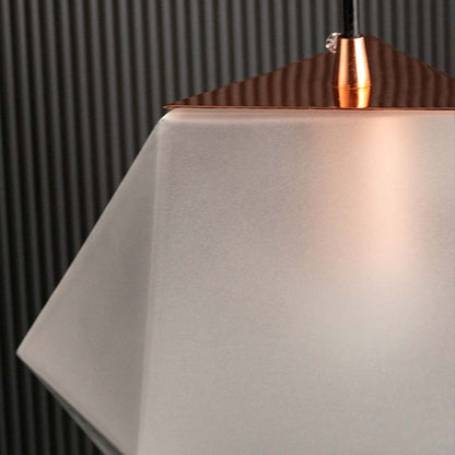 Closeup of frosted geometric pendant light showing textured faceted glass surface and warm inner glow for stylish ambient lighting.