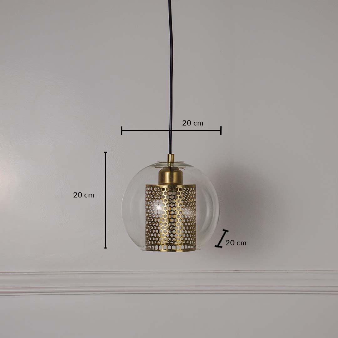 Pendant light with clear glass globe and perforated gold metal inner shade shown with dimensions 20 cm height 20 cm width and 20 cm depth on a white wall.