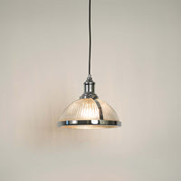 Clear glass and brass metal pendant light with warm glow for elegant contemporary home decor spaces.
