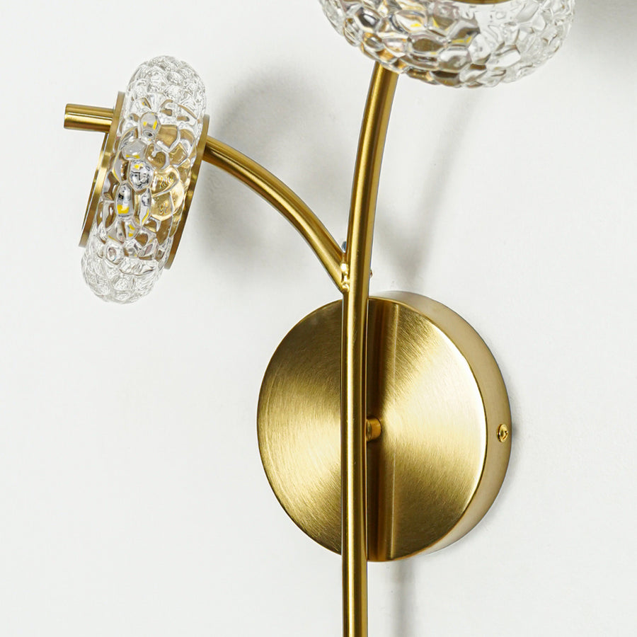 Closeup of gold metal wall light with textured crystal glass shade showing premium finish and elegant design for interior wall decor.