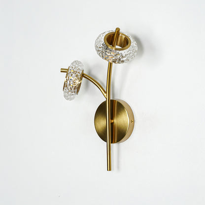 Gold metal wall light with clear glass shade and sleek arm design ideal for modern wall decor placement on clean white background.