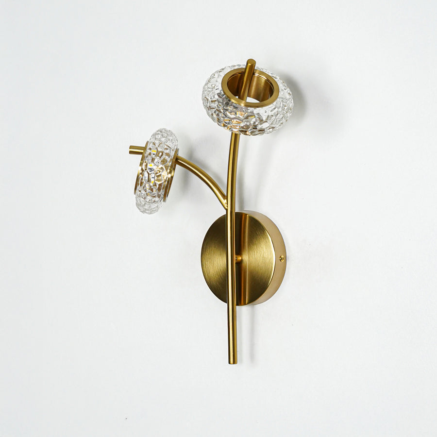 Gold metal wall light with clear glass shade and sleek arm design ideal for modern wall decor placement on clean white background.