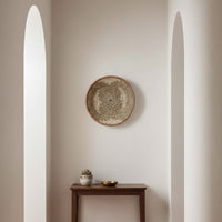 Decorative woven wall basket displayed above a minimal console table framed by arched light adding calm balance and artisanal appeal.