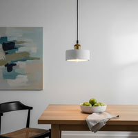 White metal pendant light above dining table adding minimalist elegance and soft ambient charm.