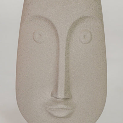 Closeup image of beige ceramic abstract face sculpture for modern shelf decor styling with matte finish display.