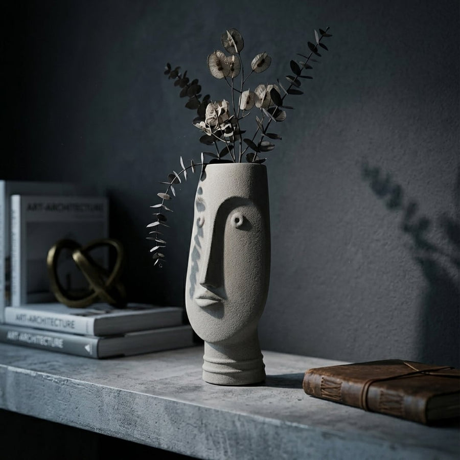 Grey ceramic face flower vase with dried stems placed on shelf for elegant modern home decor styling.