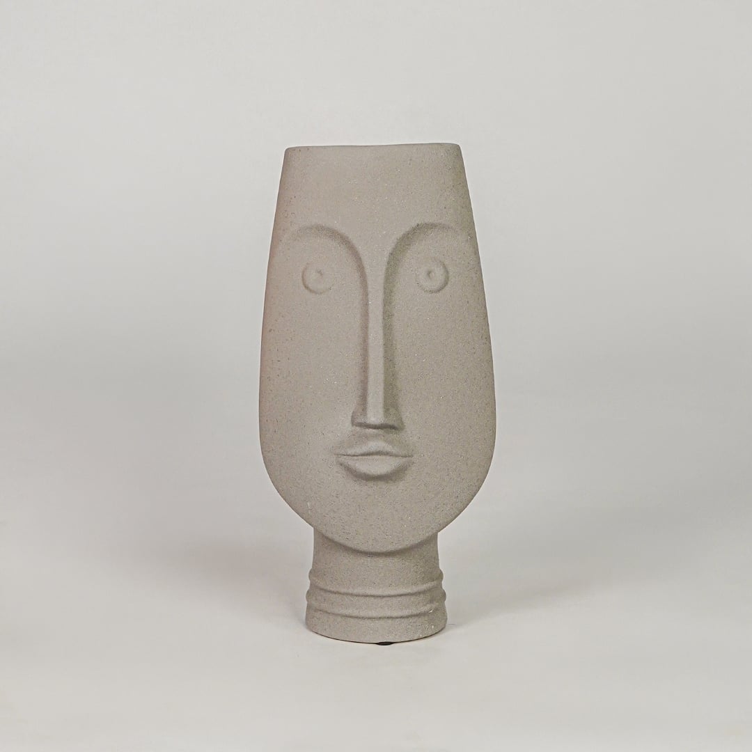 Beige face ceramic vase for modern shelf placement and elegant indoor home decor styling accent piece.
